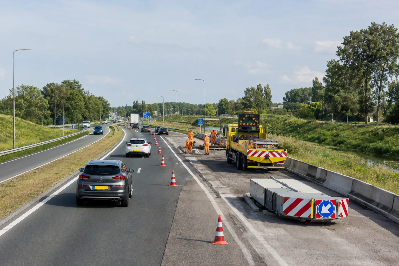 Road maintenance on the Noordelijke Randweg Utrecht, with traffic cones, workers and cars passing through an open lane.